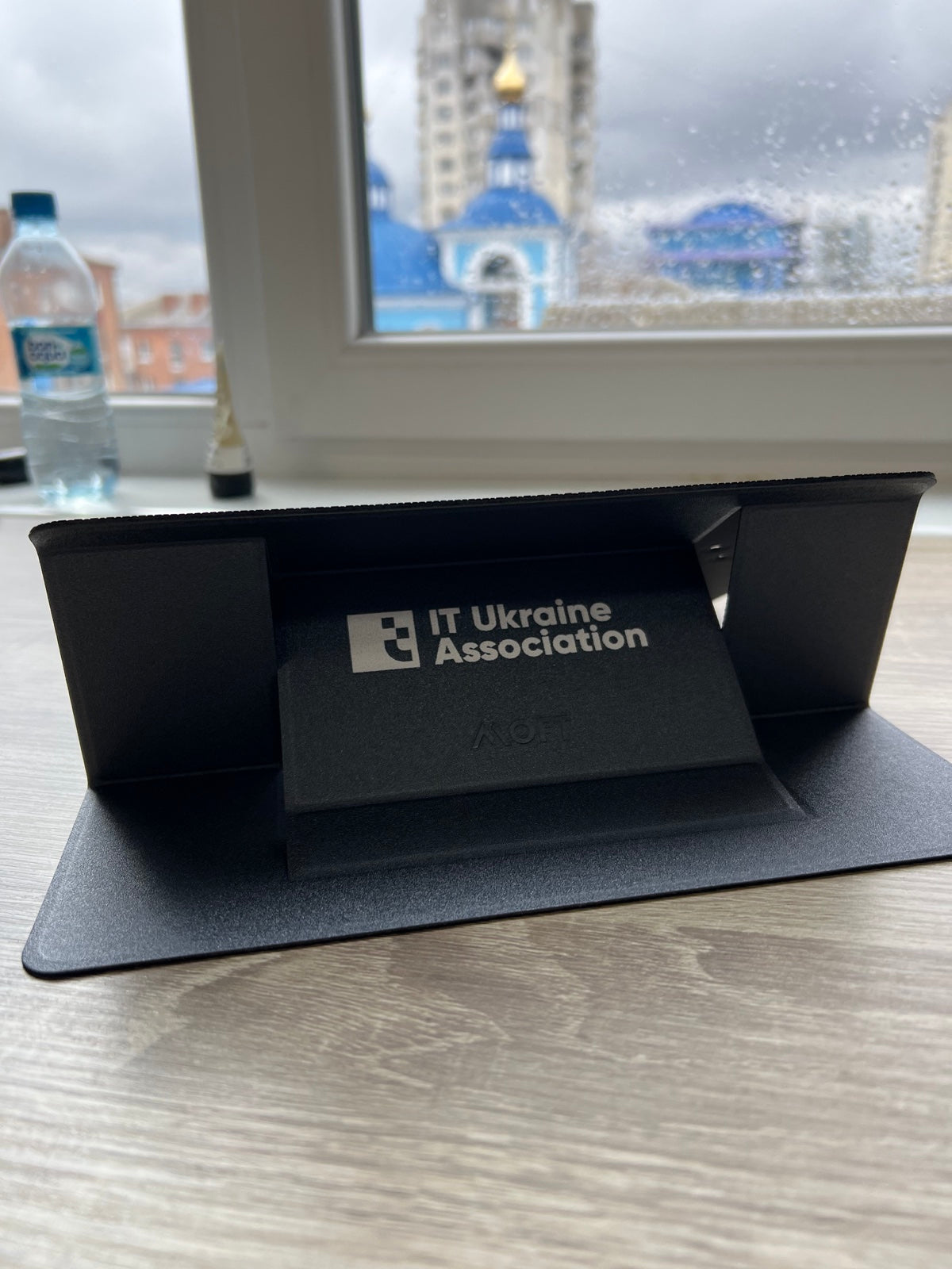 Підставка MOFT з білим логотипом IT Ukraine Association у розкладеному вигляді