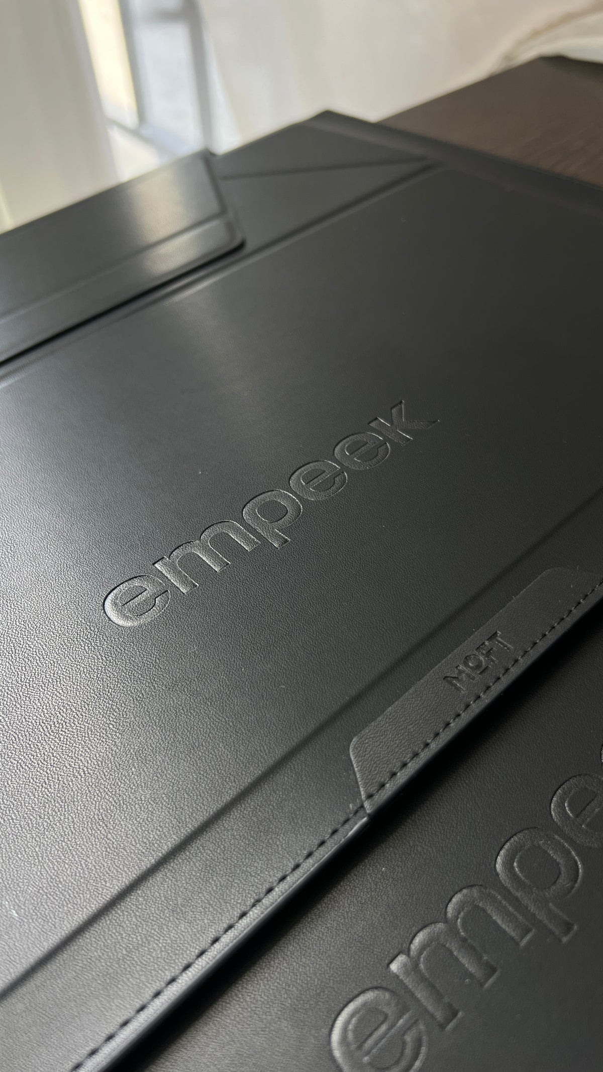 Приклад тиснення логотипу empeek на чорному аксесуарі MOFT
